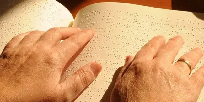 Крупный план, пальцы читают книгу со шрифтом Брайля, 13 ноября Международный день слепых, система Брайля.