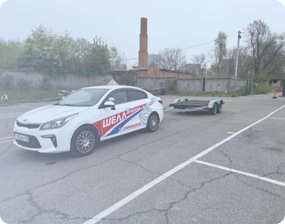 Черно-бронзовый мотоцикл стоит на стоянке у серого бетонного здания, вид сбоку