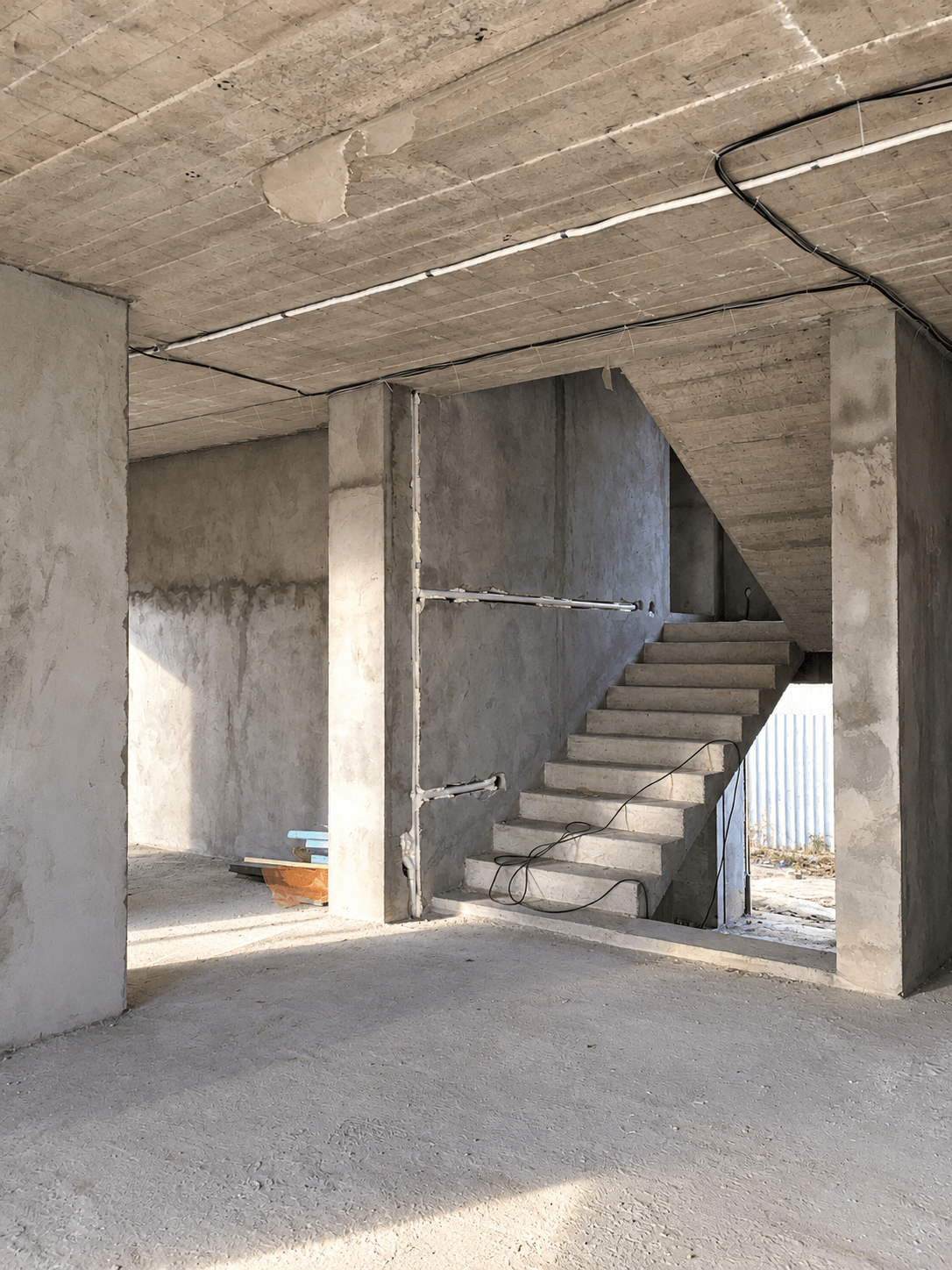 Voici à quoi ressemble généralement le point de départ d’un projet d’aménagement intérieur pour une maison à deux niveaux : une structure en béton, un escalier et un espace encore brut, qu’il reste à organiser et à façonner