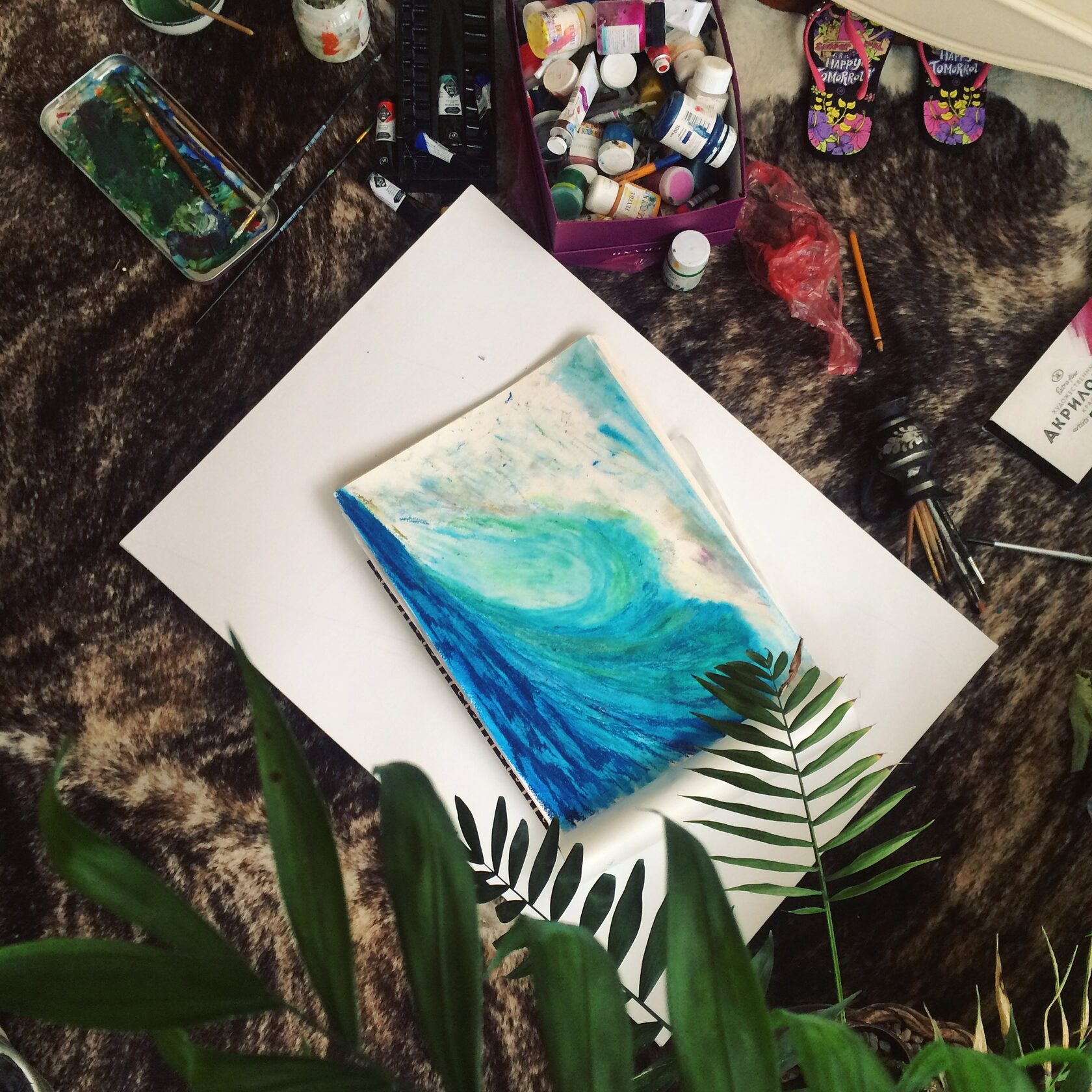 First pastel wave sketch on paper, surrounded by oil pastels and drawing materials