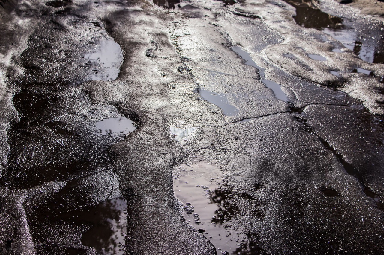 Последици от лошо асфалтиране – неравности и задържане на вода.