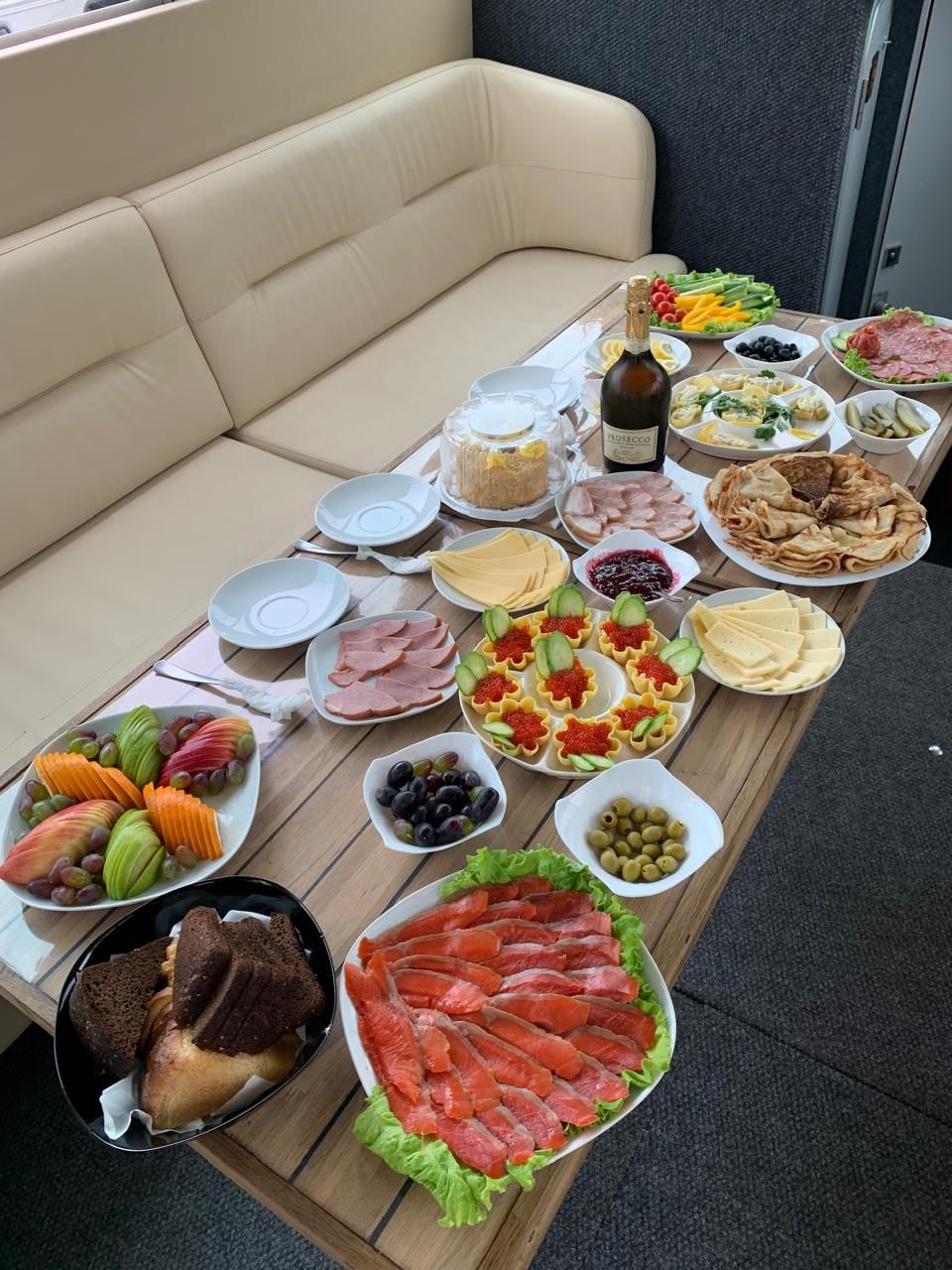 Блюда с едой и напитками на столе на борту катера на морской рыбалке на Камчатке