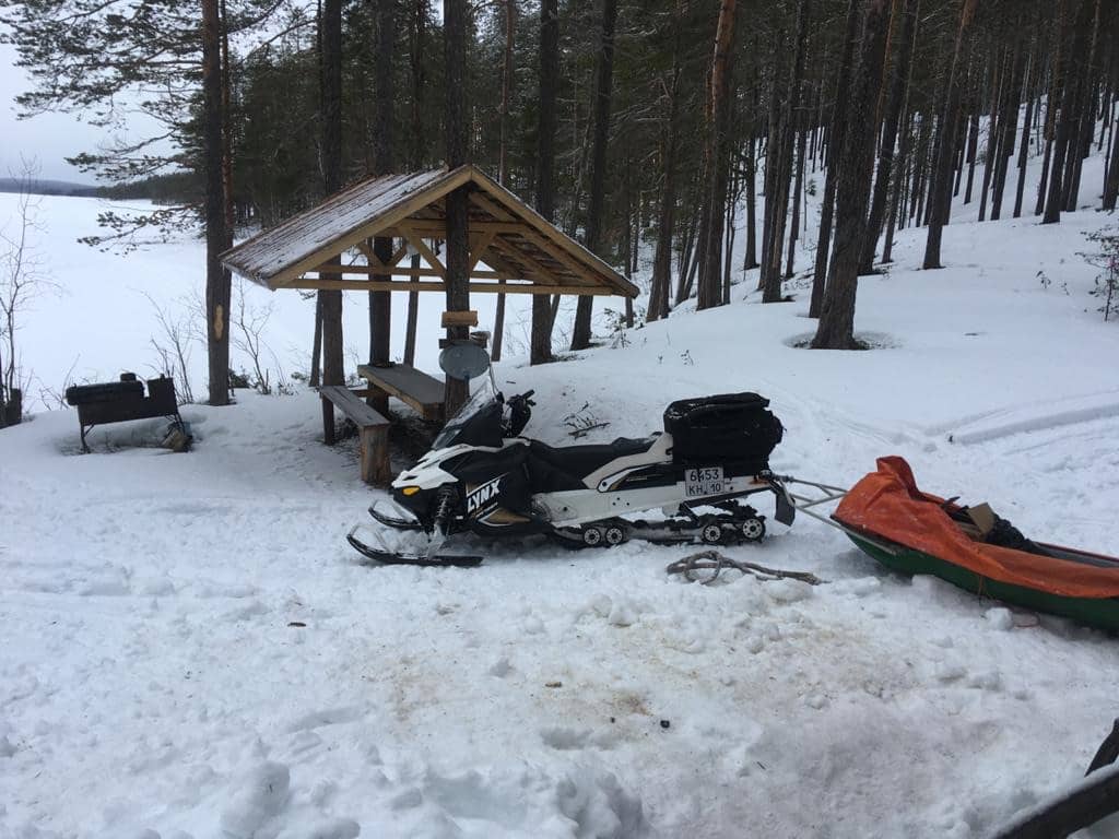 Снегоход зимой в лесу у избы
