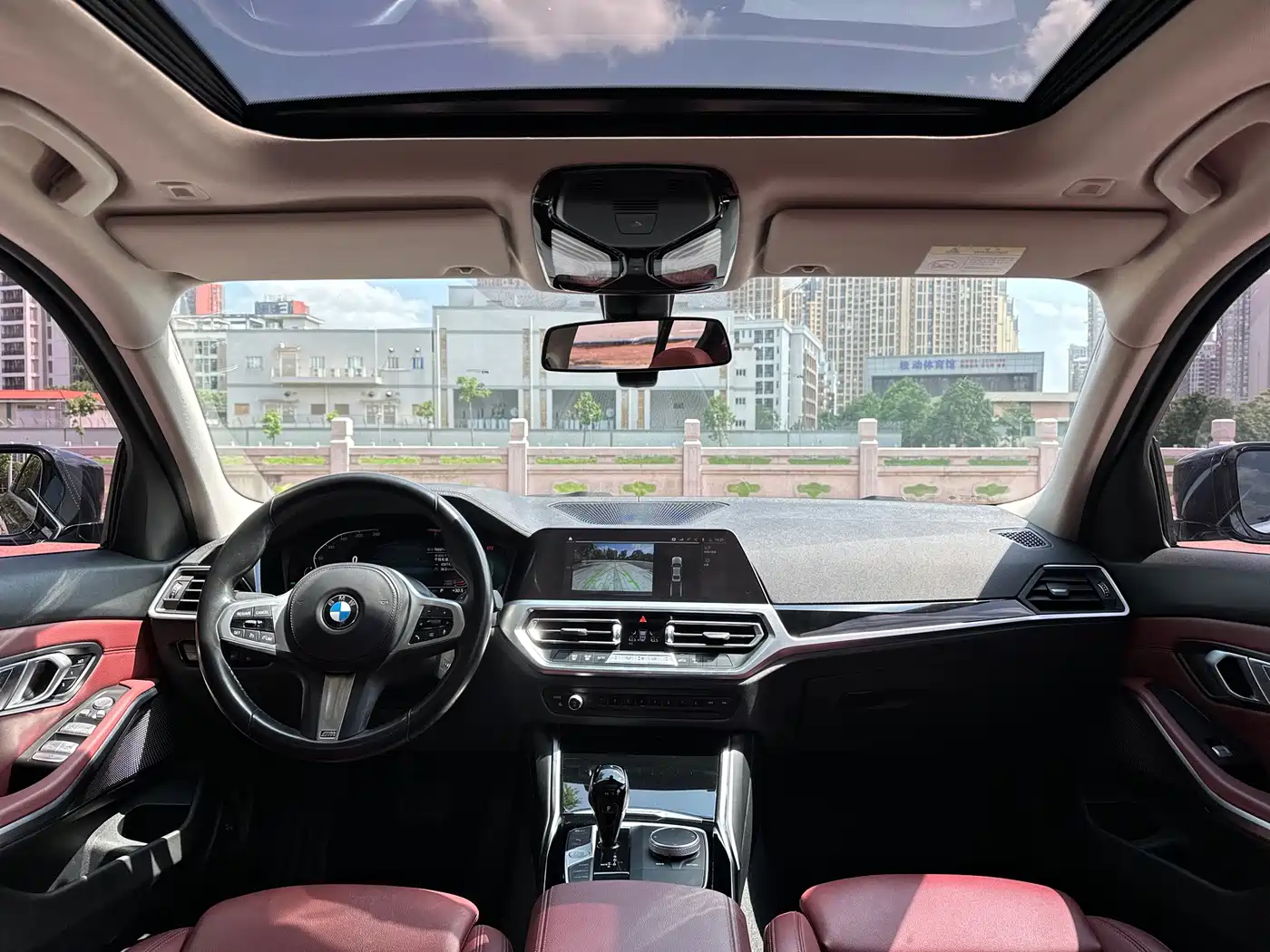 BMW 320Li G28 2022 M Sport Package — салон с красными передними сиденьями, рулём, экраном мультимедиа и стеклянной крышей