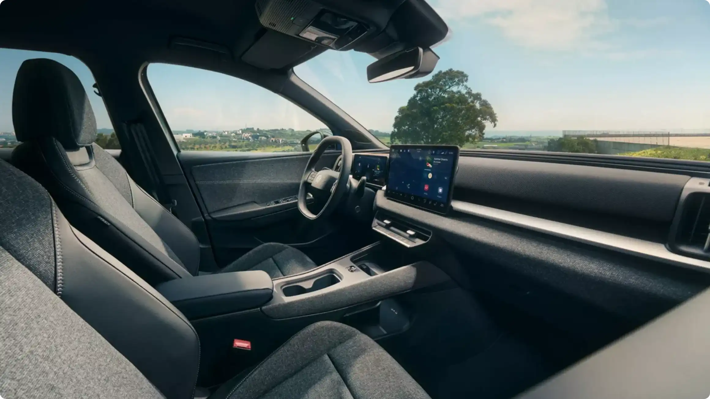 Интерьер Volkswagen ID. Cross: тканевые сиденья темно-серого цвета, 12,9-дюймовый центральный экран, цифровая приборная панель и лаконичный дизайн.