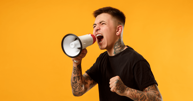 парень с татуировками кричит в мегафон