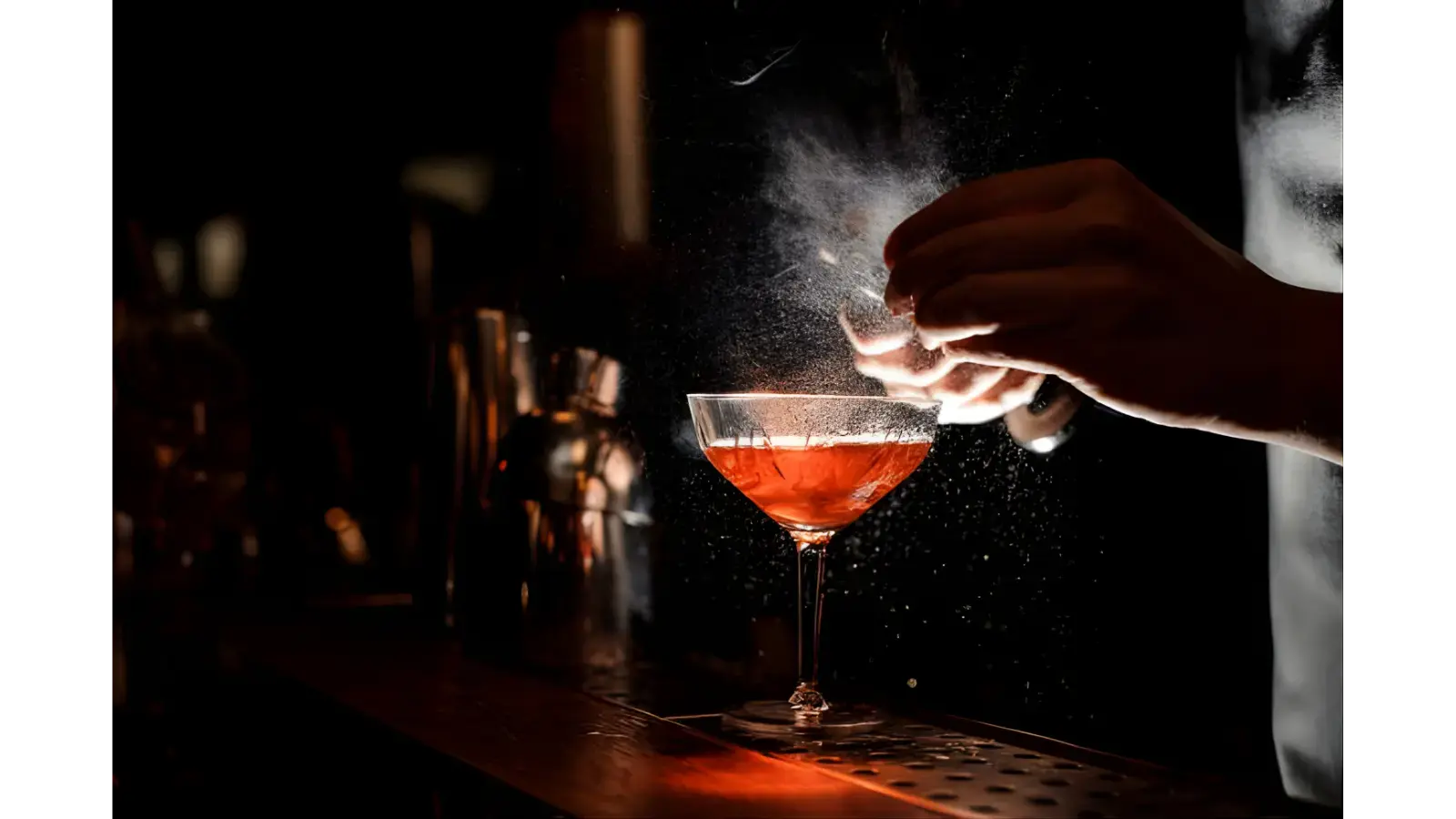 A bartender crafting a moody, aromatic cocktail under warm lighting, setting the perfect vibe for exploring the best bars in Bali.