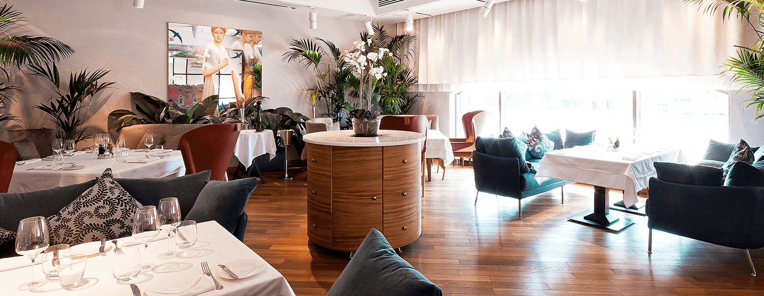 Современный ресторан сдержанного дизайна с акцентом на текстиль и живую зелень