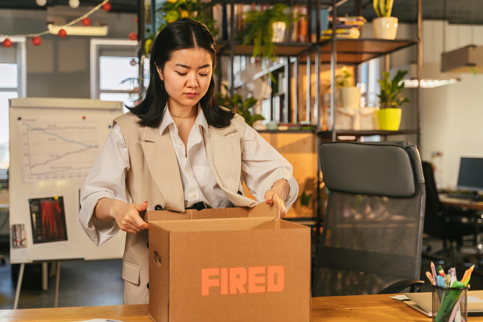 A dismissed employee packing up their belongings after being fired, symbolizing workplace dismissal.