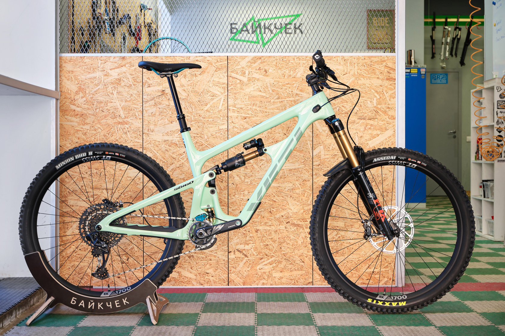 Двухподвесный велосипед Yeti SB160 мятного цвета в напольной стойке в мастерской
