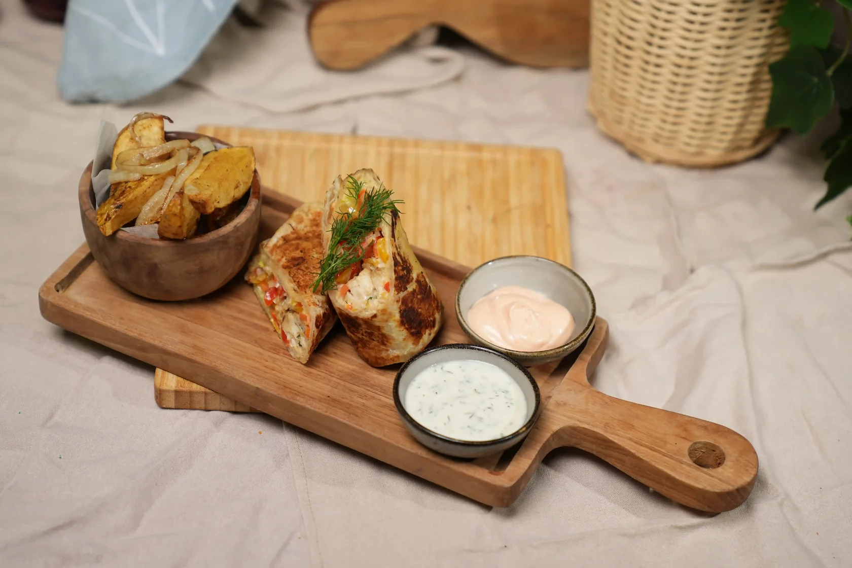 Chicken shawarma wrap with vegetables, hummus, tzatziki and potato wedges