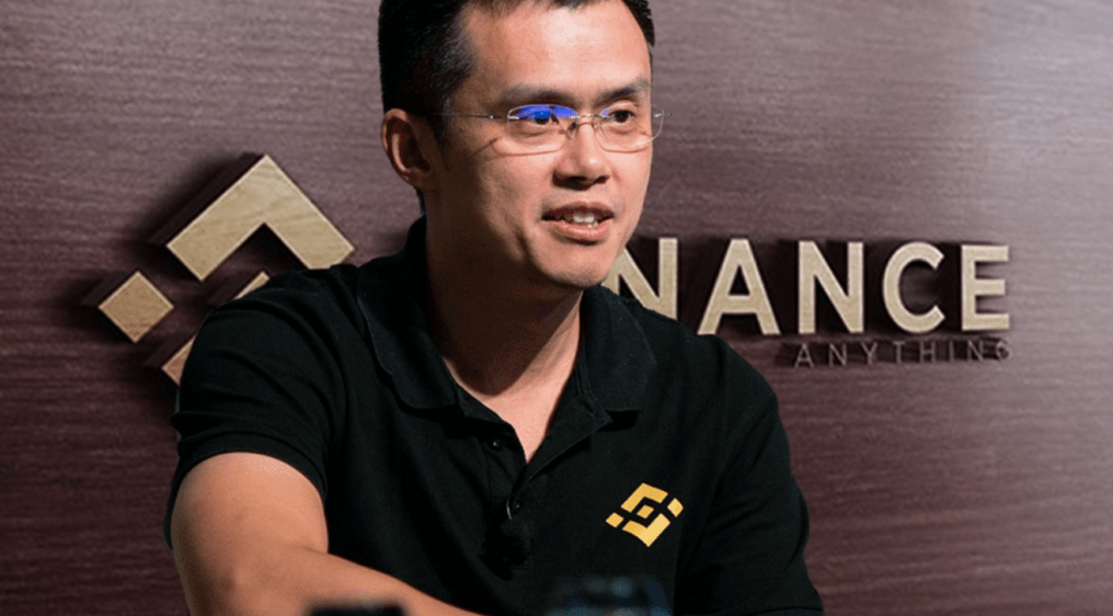 Photograph of Changpeng Zhao, the CEO of Binance, in front of a background with the company's logo.
