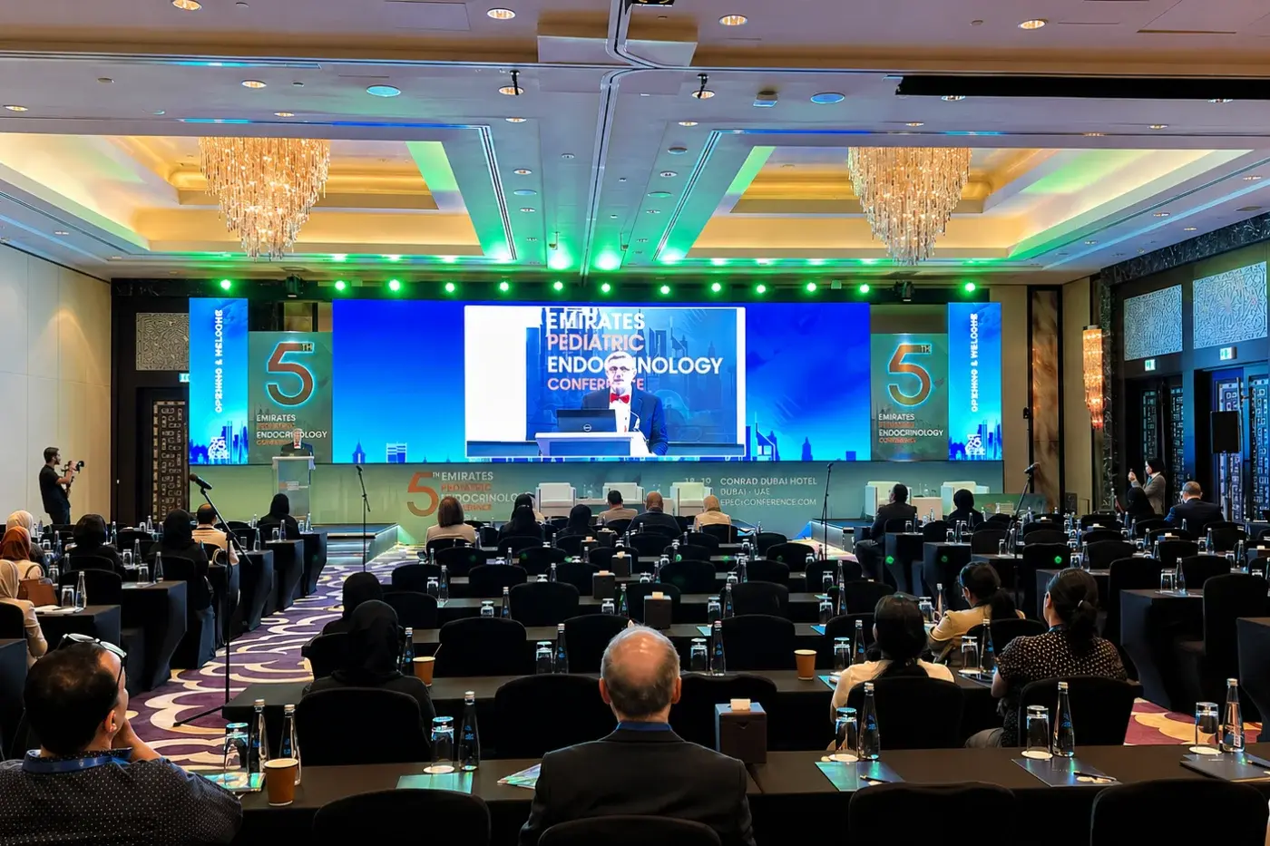 Full-width LED backdrop and stage lighting for a conference session