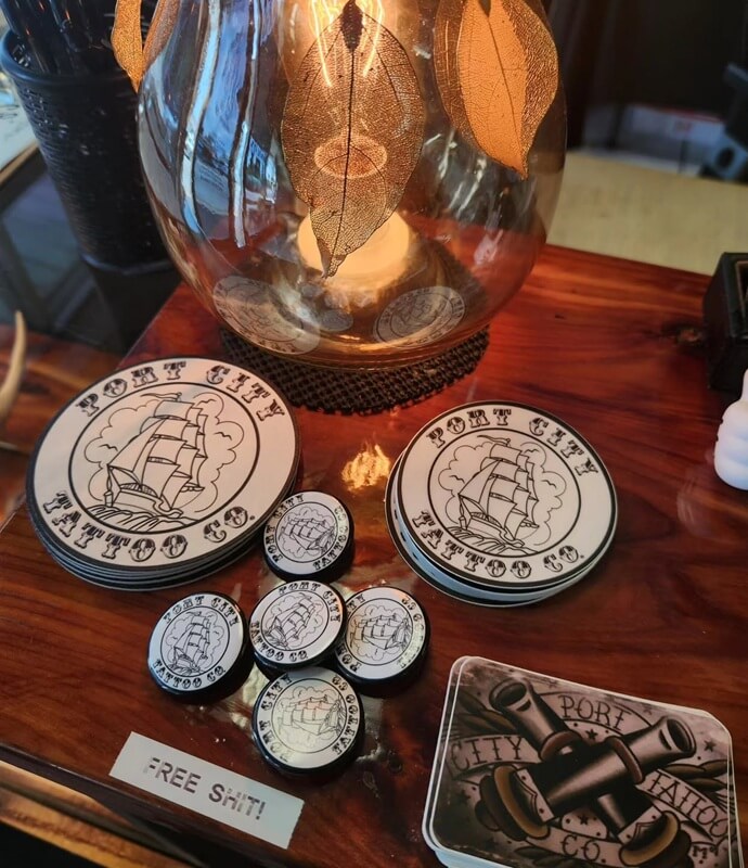 blog, Port City Tattoo Co stickers and pins with sailing ship designs at the Wilmington tattoo shop, 514