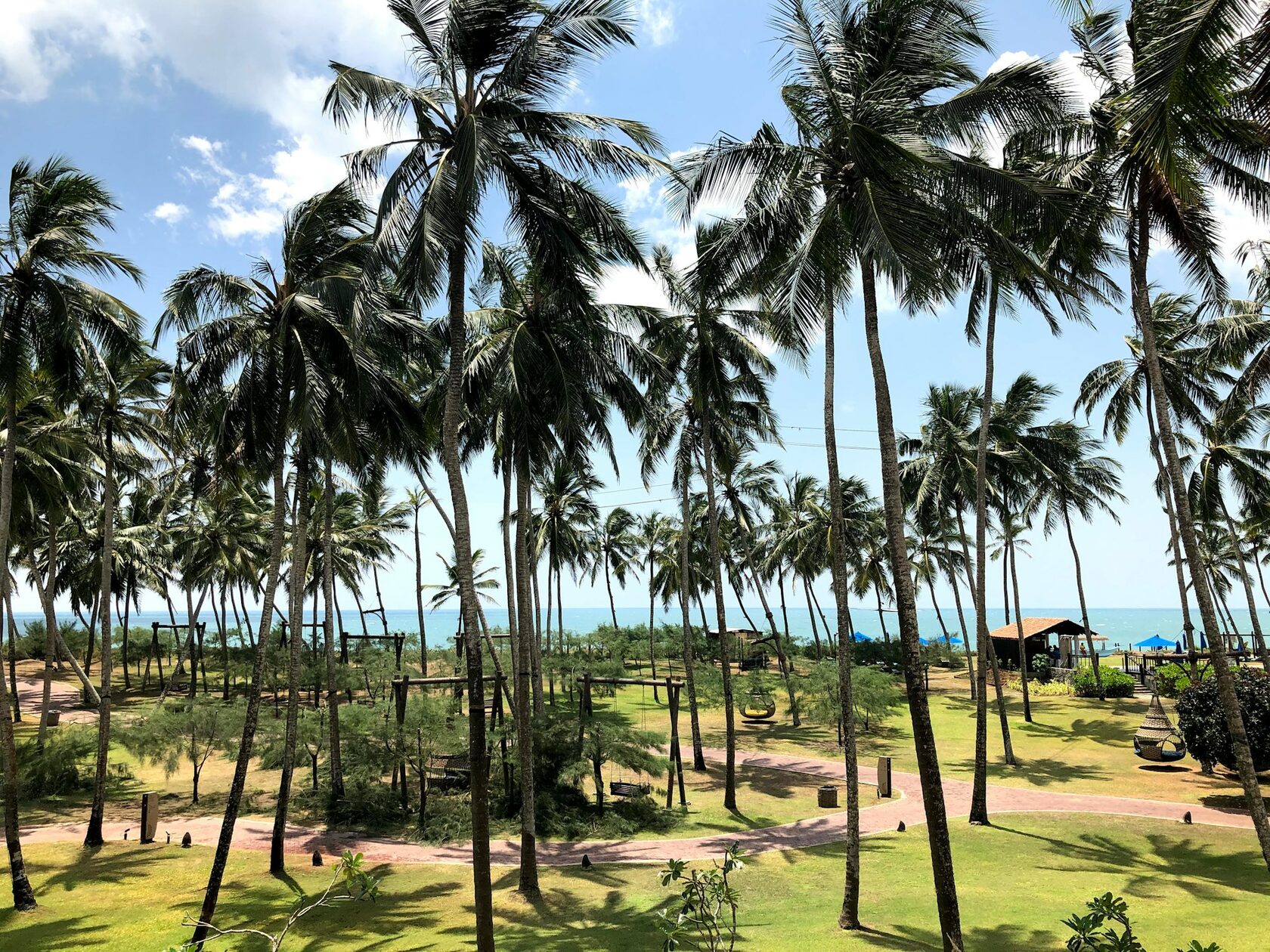 Tropical palms casting shadows across the Good Spa exterior in Weligama