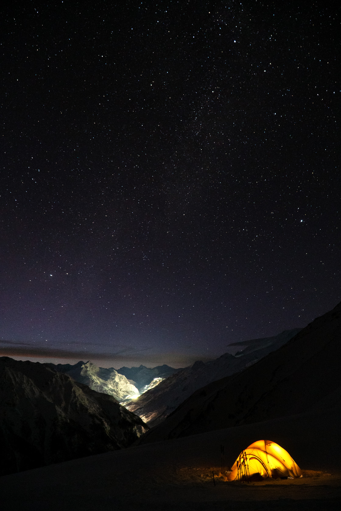 Приэльбрусье. Звездное небо. Баксанское ущелье. На склоне горы стоит желтая палатка в которой горит свет. Фотограф Севальнев Ян. 