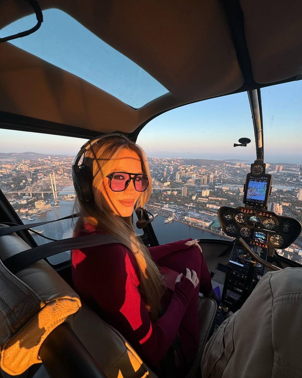 Девушка в лучах закатного солнца на вертолете