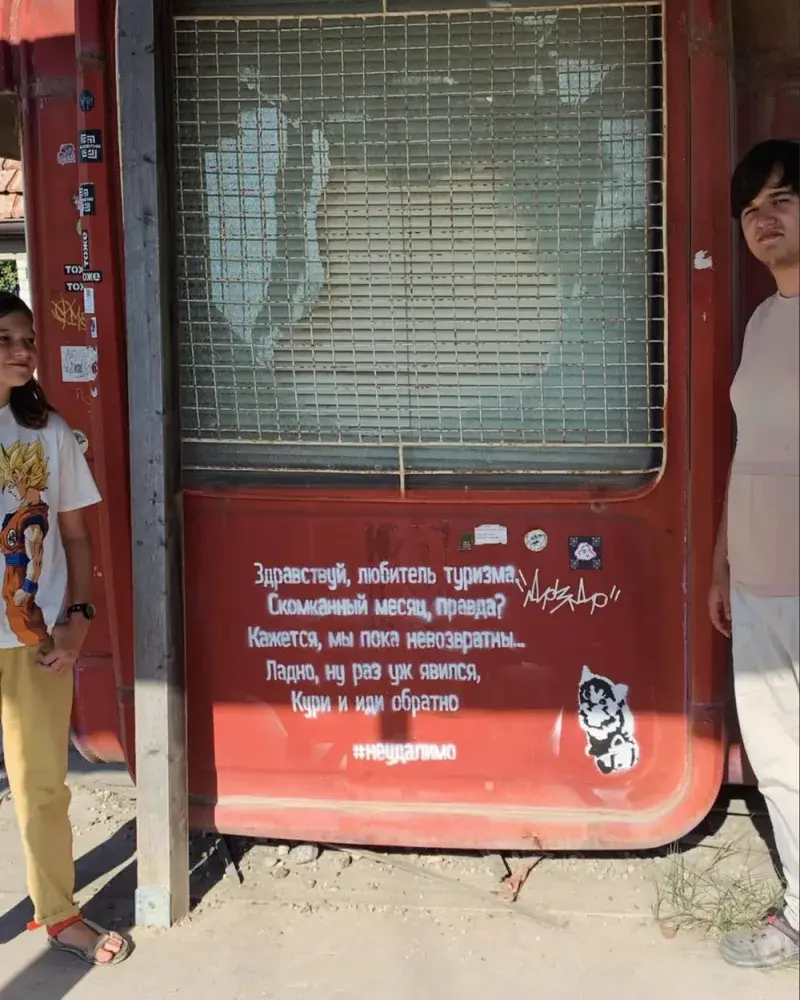 Visitors photographed on either side of the poem