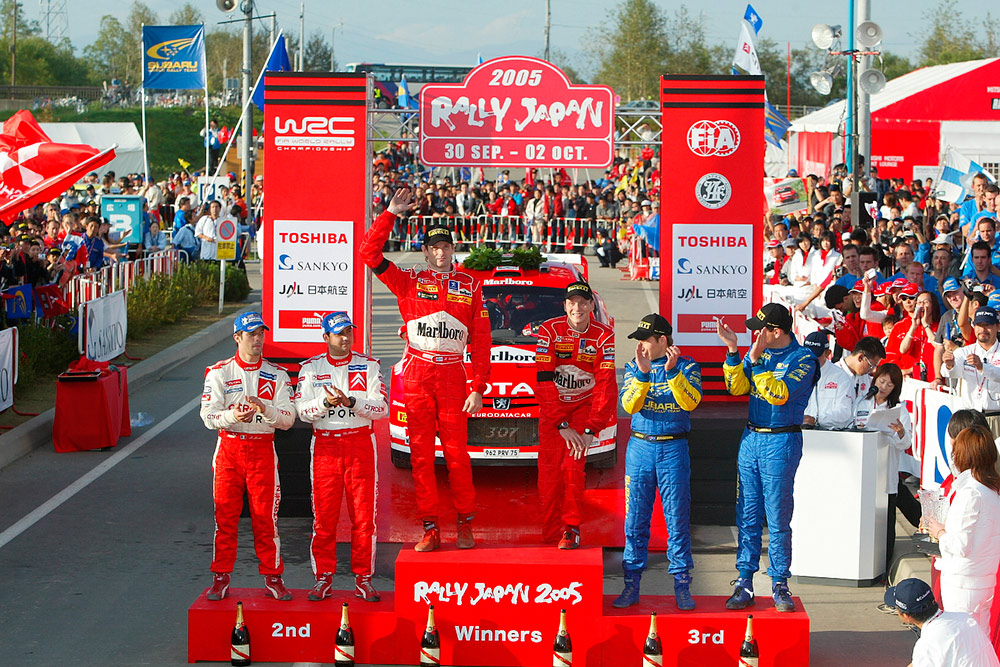 Подиум: победители ралли Япония 2005 Маркус Гронхольм и Тимо Раутиайнен (Peugeot), обладатели второго места Себастьен Лёб и Даниэль Элена (Citroën), третье место – Крис Аткинсон и Глен Макнил/Фото: Marlboro Peugeot Total