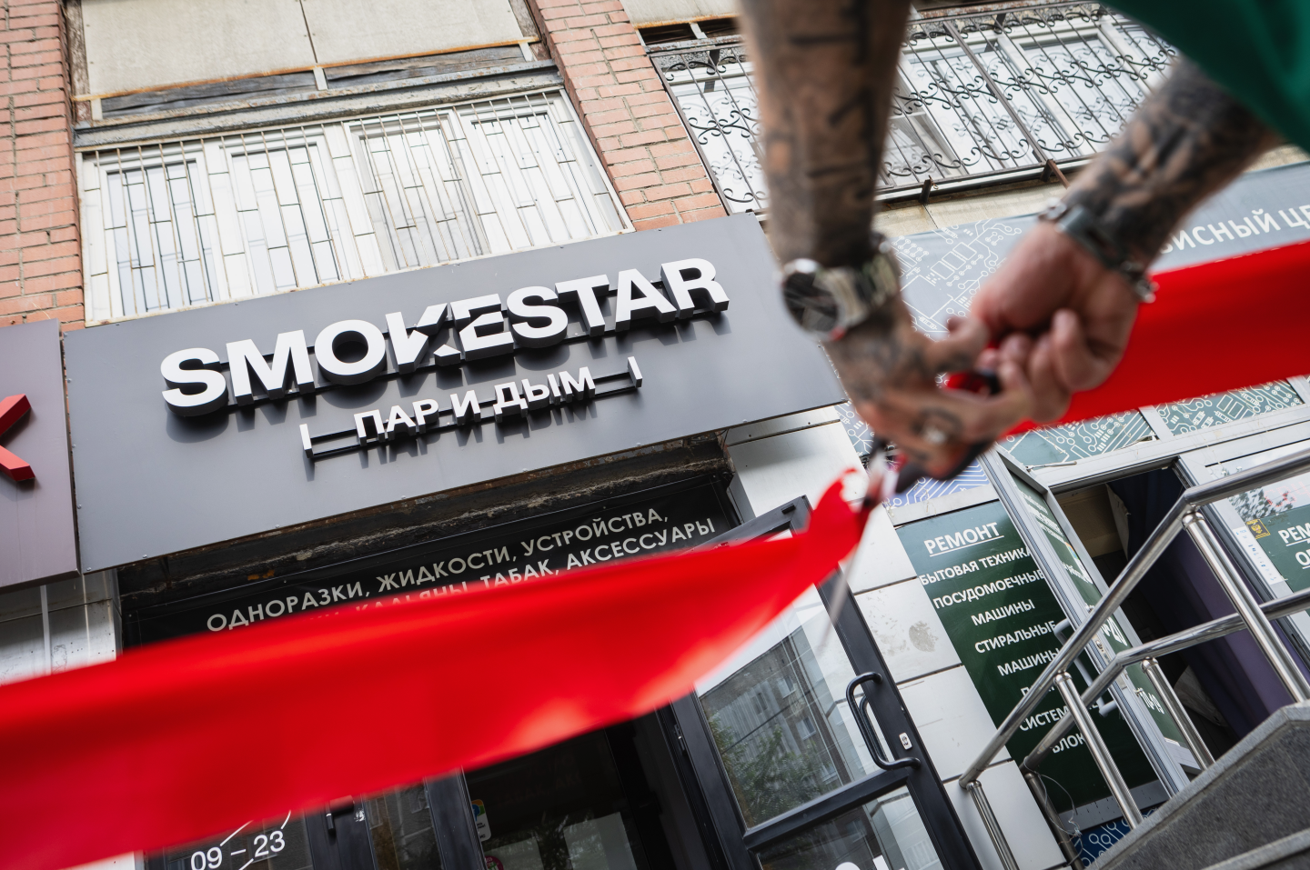 Фасад SMOKESTAR и мужчина перерезает красную ленту