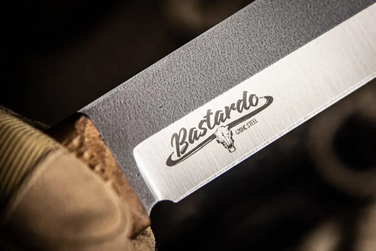 Bastardo camp knife carried in leather sheath