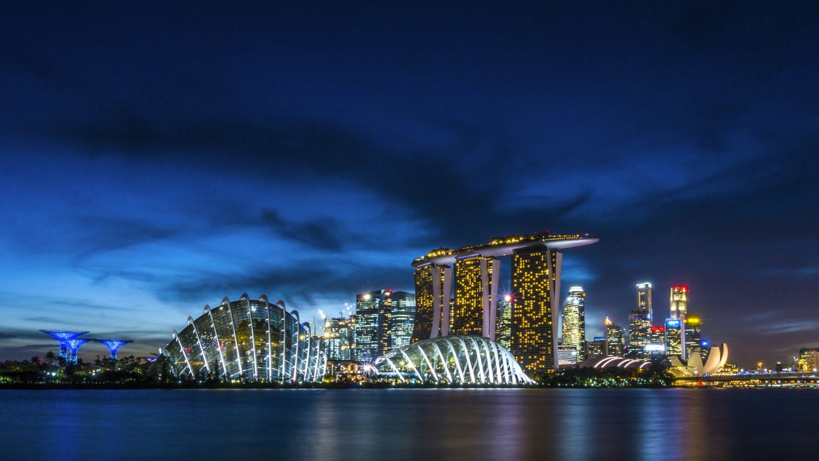 Marina Bay Sands, the Gardens by the Bay domes and the Singapore skyline lit up at dusk