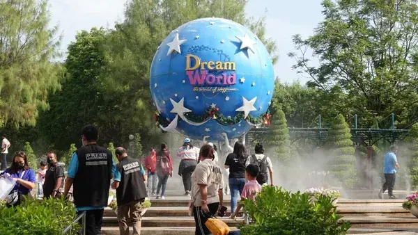 Голубой шар-глобус Dream World с логотипом над аллеей с туристами и фонтанами