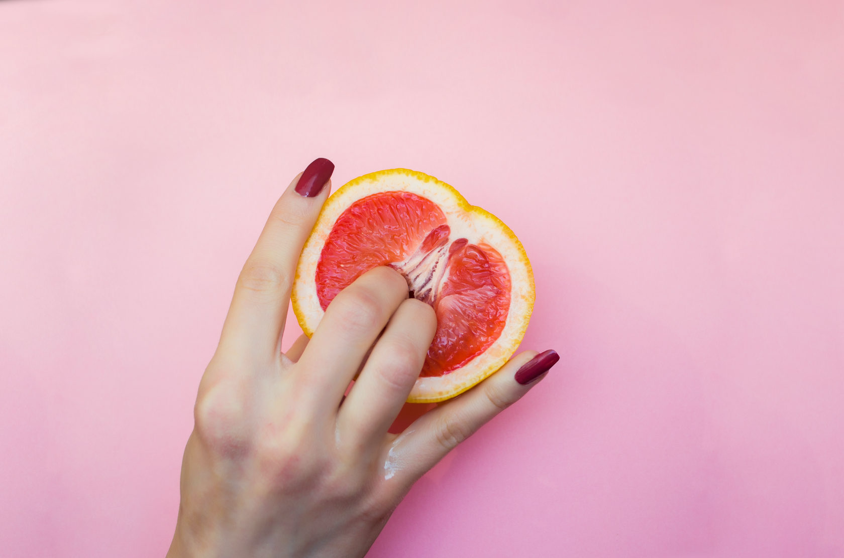 два женских пальца в грейпфруте