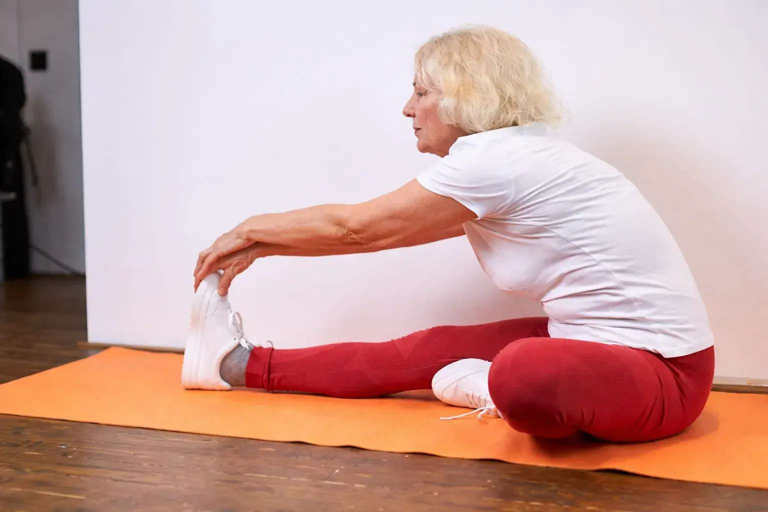 Женщина занимается растяжкой в светлой студии