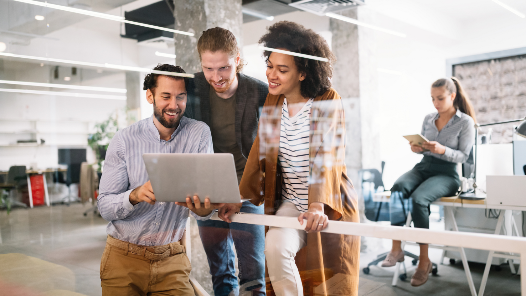 A group of professionals working on a laptop together as they assess financial resources for early-stage companies.