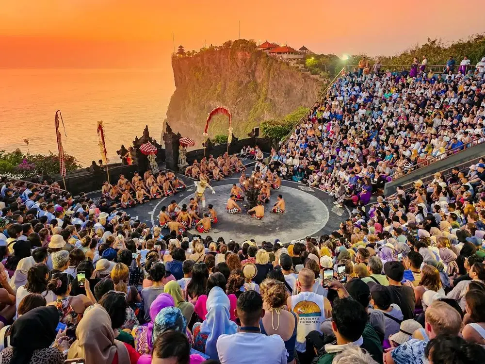 Kecak Dance performance at Uluwatu Temple during sunset with a large audience