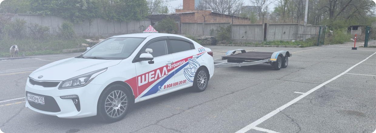 Черно-бронзовый мотоцикл стоит на стоянке у серого бетонного здания, вид сбоку