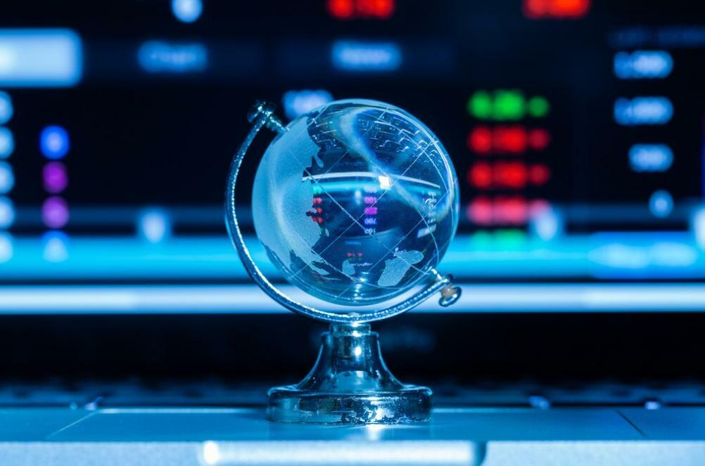 Binance restricted countries: a photograph of a glass globe in front of a cryptocurrency chart