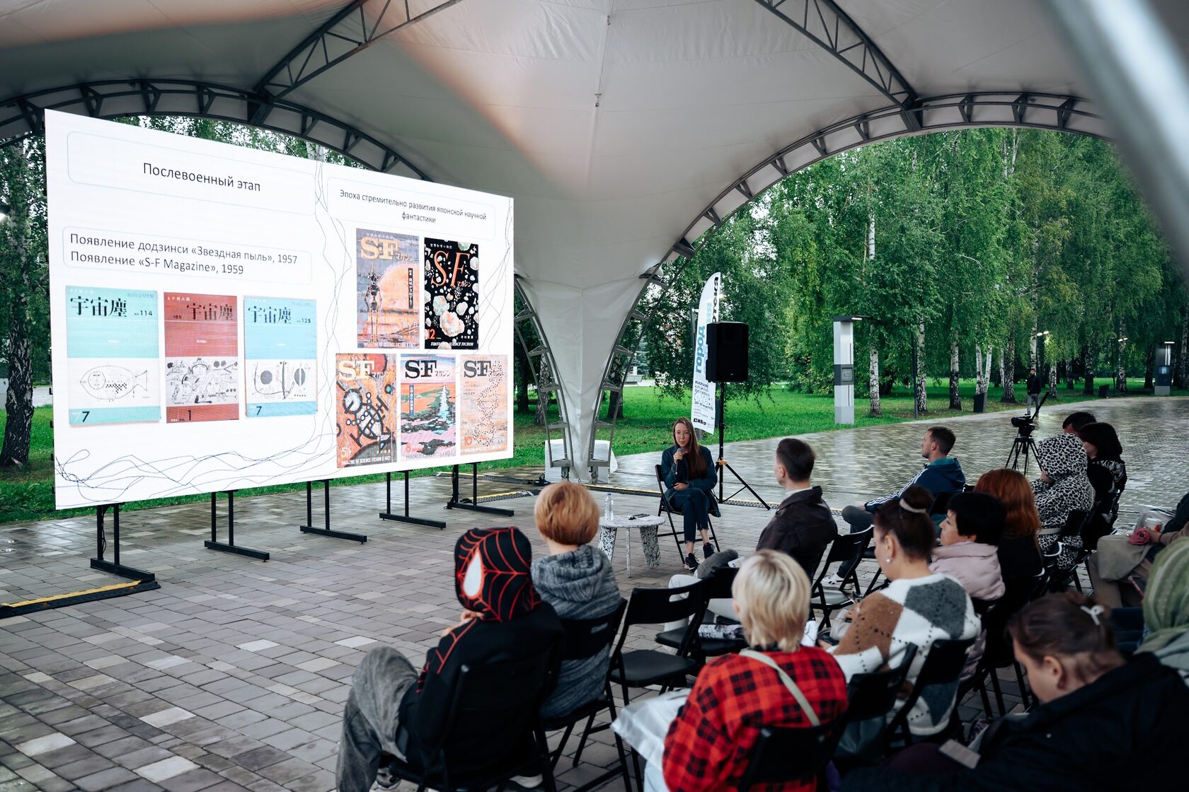 Конференция под арочным шатром, экран и ряды кресел