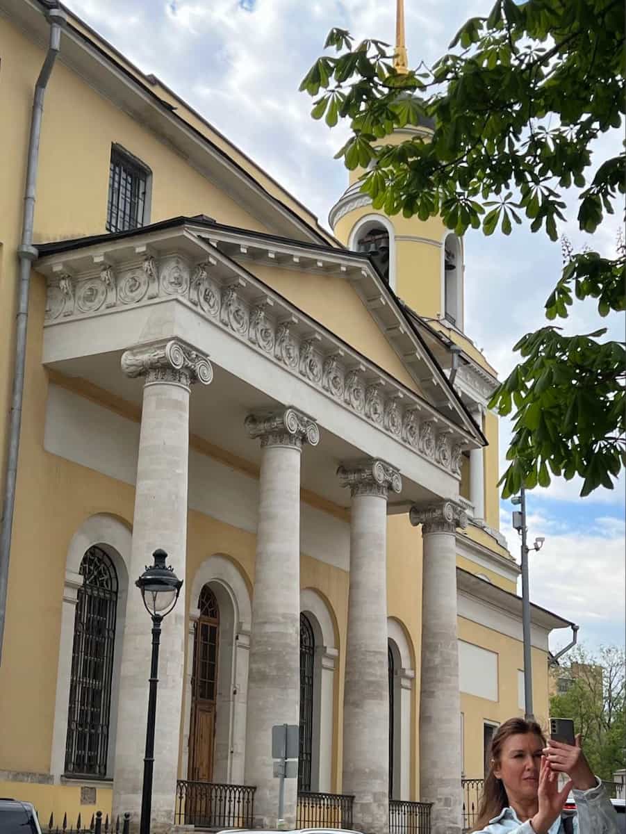 Желтый храм с колонным портиком и колокольней