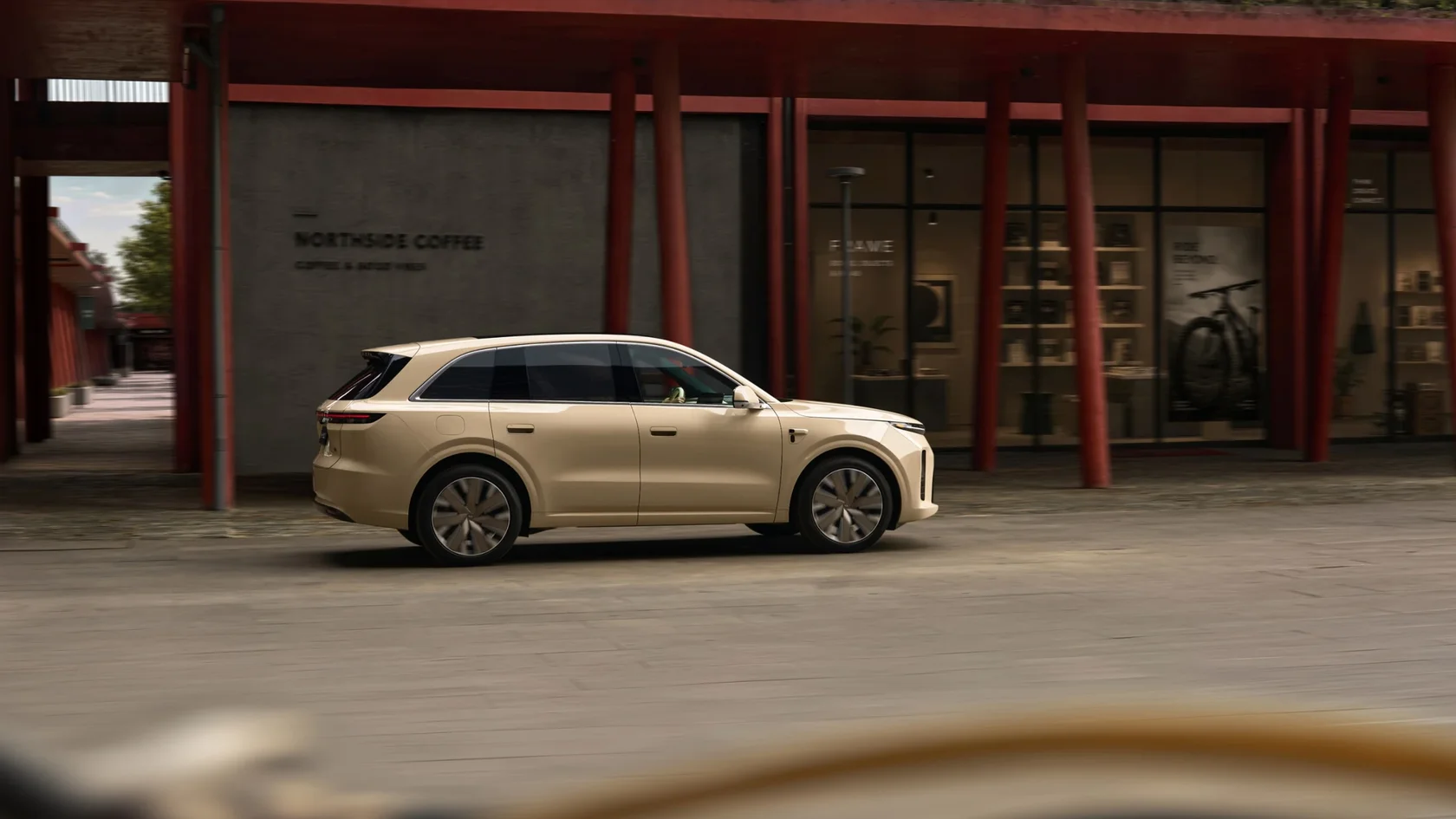 Li Auto L6 песочного цвета на фоне красных колонн