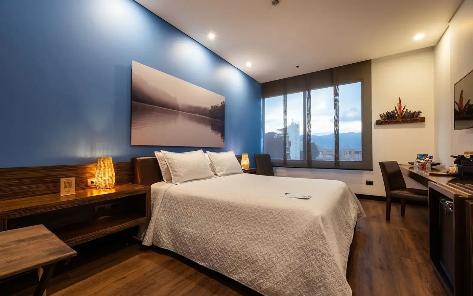 Номер с деревянным полом, синей стеной и окном на горы, Diez Hotel Medellín