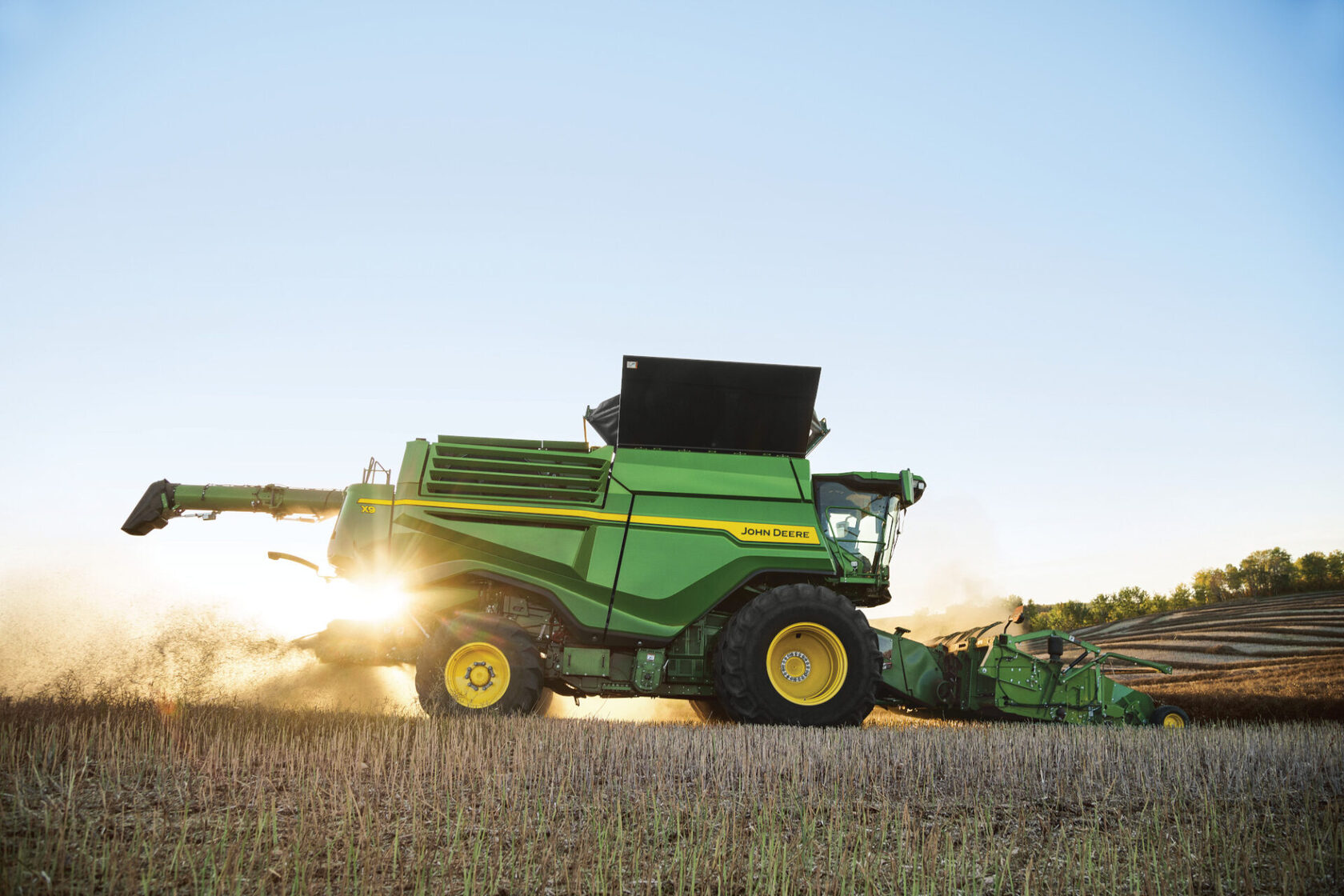 Комбайн John Deere X9 в поле на закате