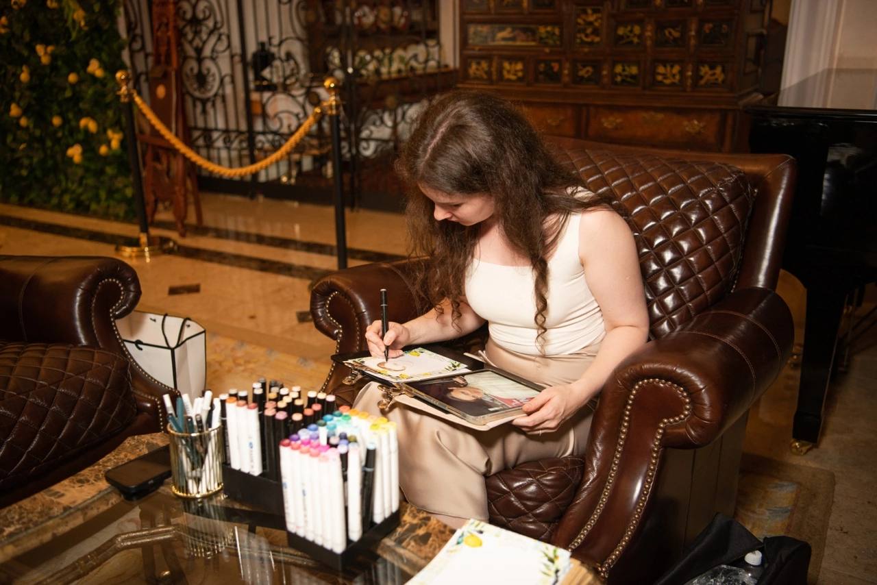 Арина рисует гостей маркерами в кресле в интерьере особняка