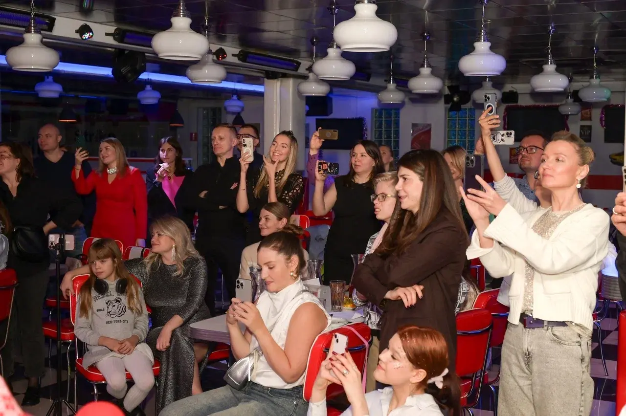 Родители смотрят выступление детей на новогоднем празднике