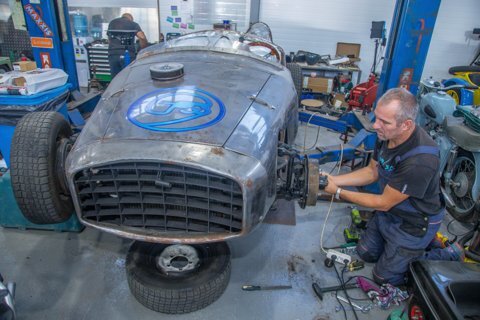Мужчина у колеса автомобиля в мастерской