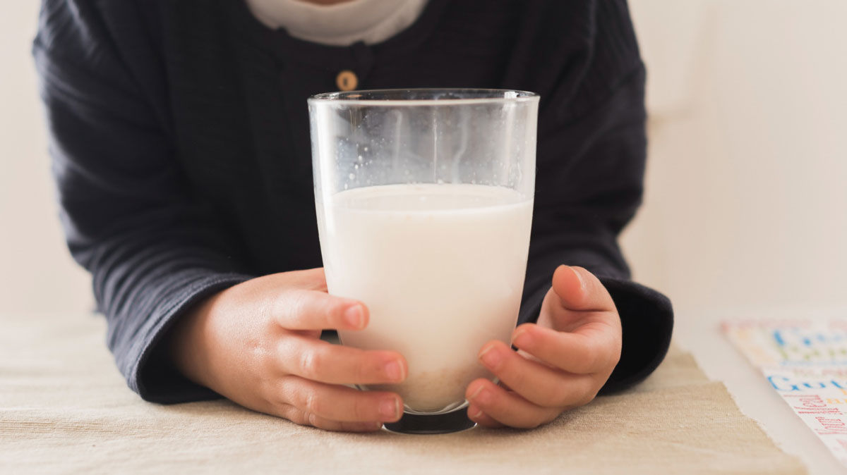 стакан молока в руках малыша