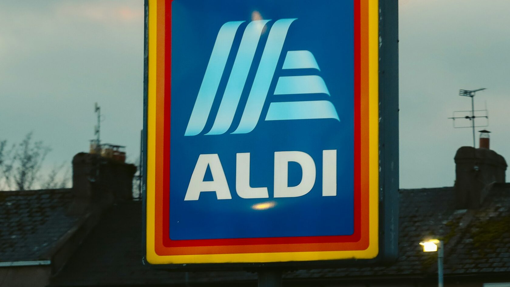 A blue and yellow ALDI sign in front of a building