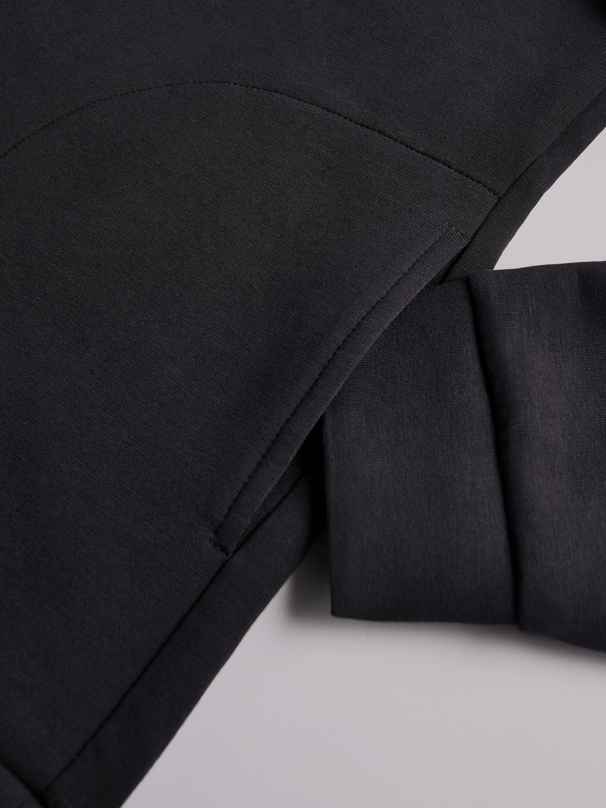 рукав черной толстовки на нейтральном фоне