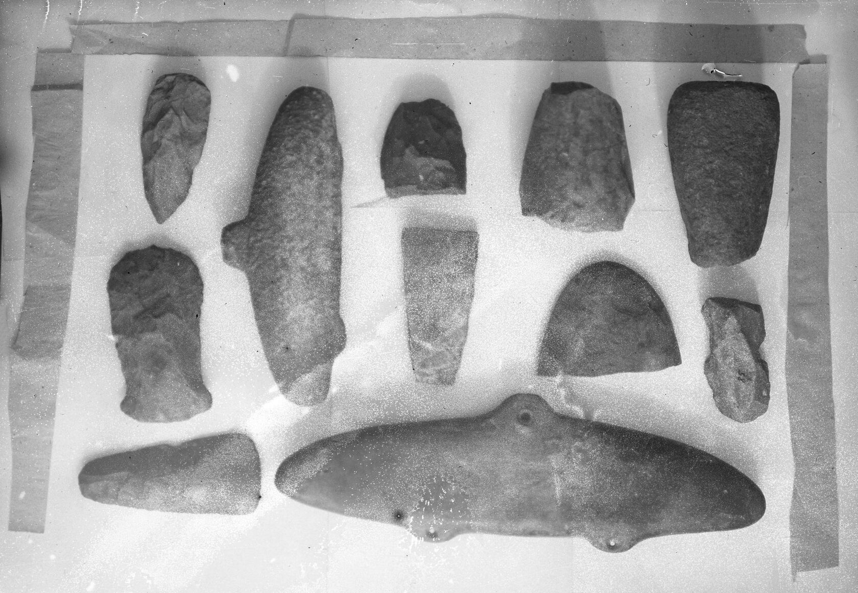 Каменные рыбки, топоры, тесла, наконечники копий эпохи неолита. Ангарский край. 1920-е