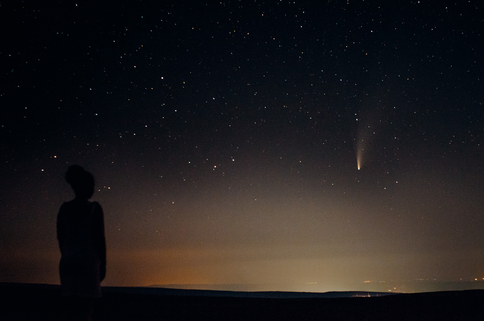Фотография кометы C/2020 F3 (NEOWISE) на фоне человека смотрящего в небо. Фотограф Севальнев Ян.