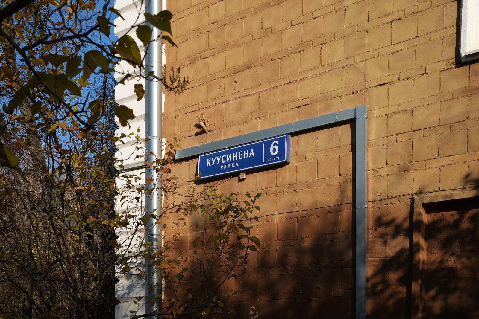 Табличка «улица Куусинена, 6, корпус 1» на кирпичном доме у выезда из Берёзовой рощи