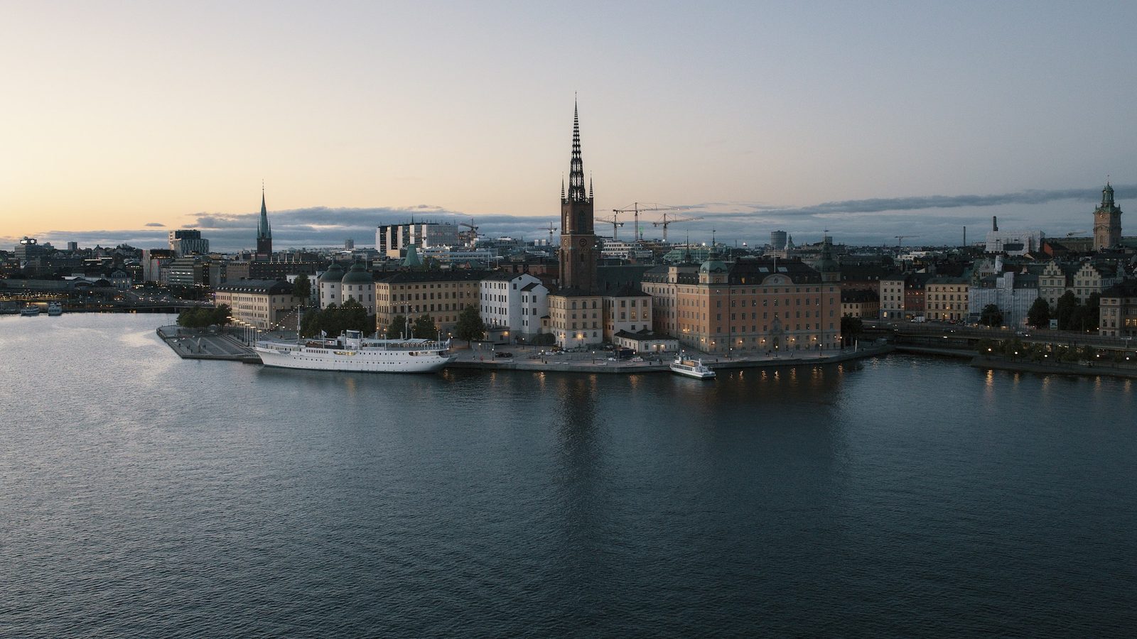 Riddarholmen island in Stockholm at dusk, with the spire of Riddarholm Church and old palaces on the waterfront of Riddarfjärden
