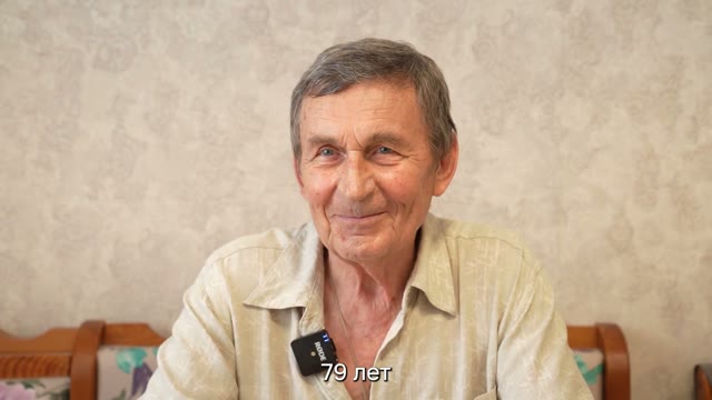 Социальный помощник Лариса Базанова просматривает альбом с Алексеем Гладышевым