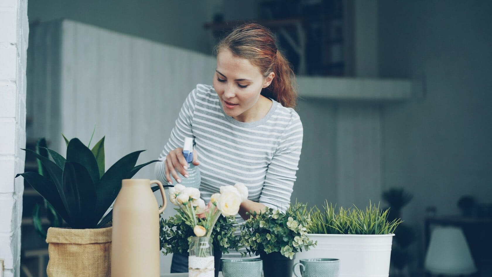 Woman caring for fresh flowers at home with soft floral arrangement for flower delivery inspiration